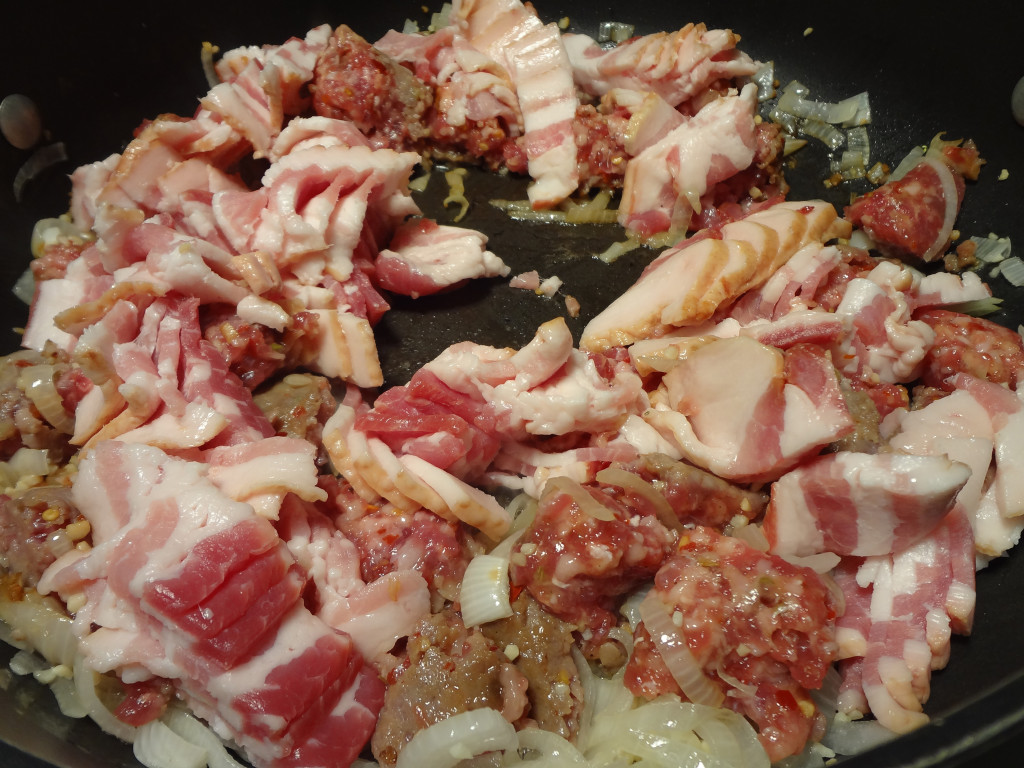 Cooking onions, garlic, bacon, and sausage
