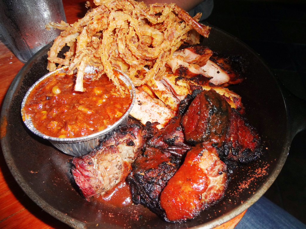 Two-meat plate: burnt ends and char-smoked chicken with onion hay and Brunswick stew