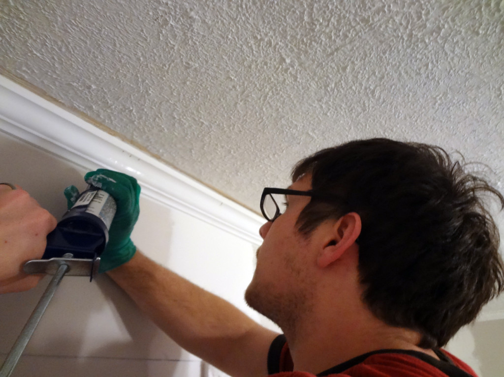 Makng over the den: caulking the trim