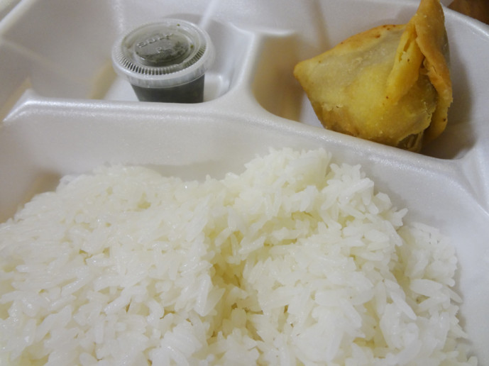 A chicken samosa with chutney and complimentary rice.